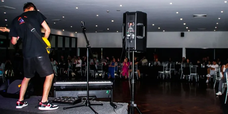 Student performing live guitar on stage at a Rob's Guitar & Drum Lessons showcase